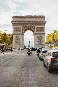 an arch in the middle of a street with cars at Chic Apartment in the Prestigious Saint Honoré in Paris