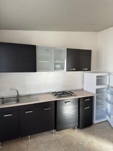 una cucina con armadi in bianco e nero e un lavandino di Sunset Village a Marina di Montenero