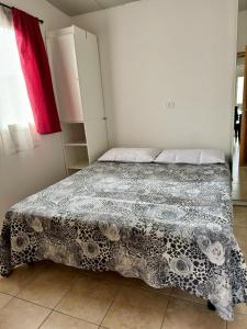 una camera da letto con un letto con un piumone bianco e nero di Sunset Village a Marina di Montenero