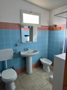 bagno piastrellato blu con servizi igienici e lavandino di Sunset Village a Marina di Montenero Altre 26 foto