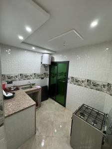 a kitchen with a stove and a green door at Magnifique appartement in Derroua