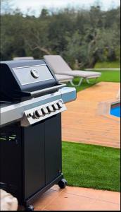 a barbecue grill sitting on top of a patio at Villa Lima Pool & Jacuzzi Chania in Vamos