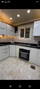 a kitchen with white cabinets and a stove top oven at Dokki in Cairo