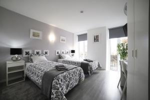 una camera d'albergo con due letti e una finestra di Guest House Triunfo a Porto
