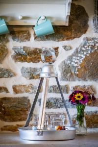 a lamp on a table with a vase of flowers at RODON Luxury Villas in Skopelos Town