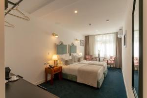 une chambre d'hôtel avec un lit et une table dans l'établissement Westlight Lisboa Madalena, à Lisbonne