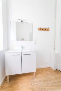 a white bathroom with a sink and a mirror at La Villa Lumière - 3 chambres in Tulle +32 photos