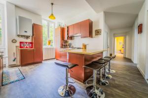 a kitchen with a counter and some stools in it at La Villa Lumière - 3 chambres in Tulle