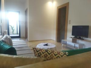 un salon avec un canapé et une télévision à écran plat dans l'établissement Majesty home, à La Marsa