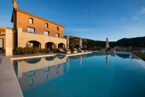 a large swimming pool in front of a building at Reveli Suites in Katelios