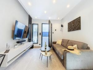 a living room with a couch and a tv at La Suite EDEN - Maison de ville Luxe - 4pers - Jacuzzi - 10min Cannes in Le Cannet