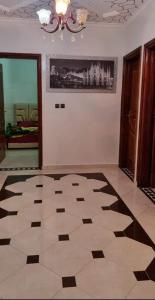 una camera con pavimento a scacchi e lampadario a braccio di تجزئة القلم حي أطلس بني ملال 