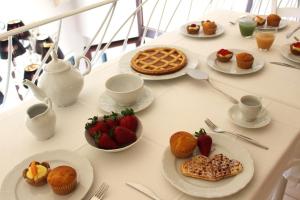 einen Tisch mit Teller mit Lebensmitteln und Obst in der Unterkunft Palazzo Aurora in Alezio