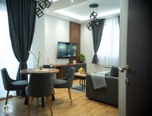 a living room with a table and a couch at Tesoro apartmani Spa&Wellness in Zlatibor