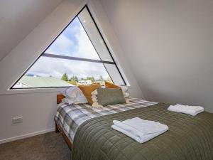 a bed in a room with a large window at Findlay Chalet - National Park Holiday Home in National Park