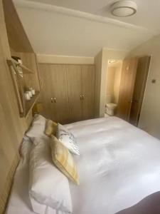 a bedroom with a white bed with two pillows at Lakeside Escape Modern 2 Bedroom Holiday Home in Overstone