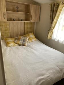 a white bed with two pillows in a bedroom at Lakeside Escape Modern 2 Bedroom Holiday Home in Overstone