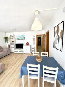 comedor y sala de estar con mesa azul y sillas en Apartamento Ciudamar, en Puerto Sagunto