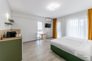 オトペニにあるOtopeni Suites by CityBookingsのベッドとテーブルが備わるホテルルームです。