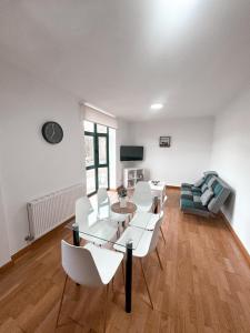 a living room with a table and chairs and a couch at PortoHome I in Portomarin