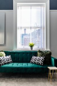 ein grünes Sofa im Wohnzimmer mit Fenster in der Unterkunft Coppergate Mews Grimsby No.5 - 1 bed, 1 bath, 1st floor apartment in Grimsby