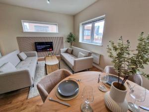 sala de estar con mesa y sofá en Free Parking Stunning City Centre Flat en Mánchester