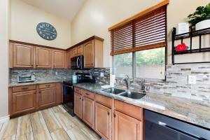 a kitchen with wooden cabinets and a sink and a window at The Beach House in Surprise +30 photos