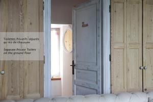 a white door with a sign on it in a room at La Martinoise Patio in Saint-Martin-de-Ré