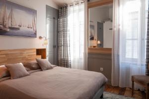 a bedroom with a large bed and a window at La Martinoise Patio in Saint-Martin-de-Ré