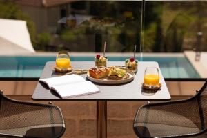 a table with a plate of food and two glasses of orange juice at Reveli Suites in Katelios