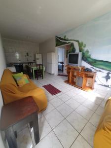 salon z żółtą kanapą i telewizorem w obiekcie Apartamento Divina Ilha w mieście Ilha Comprida