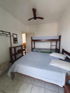 sypialnia z dużym białym łóżkiem i wentylatorem sufitowym w obiekcie Apartamento Divina Ilha w mieście Ilha Comprida