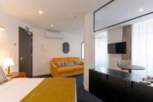 a hotel room with a bed and a couch at Westlight Lisboa Madalena in Lisbon