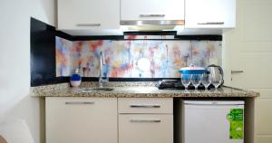 une cuisine avec des placards blancs et un tableau mural. dans l'établissement Taksim Next Hotel, à Istanbul