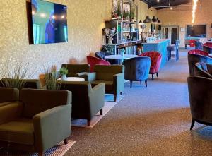 poczekalnia z krzesłami i stołami oraz bar w obiekcie Bishops Park At Fingle Glen Golf Hotel w mieście Exeter
