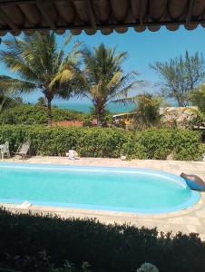 貝貝里比的住宿－Pousada sol nascente，一个种有棕榈树的大型蓝色游泳池