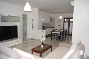 a living room with a couch and a tv and a table at Casa Ulivo in Pulsano