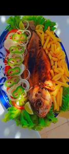 a plate of food with meat and french fries at Pousada sol nascente in Beberibe