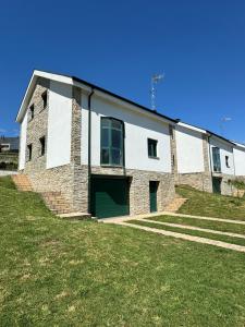 a large brick building with a green door at PortoHome I in Portomarin