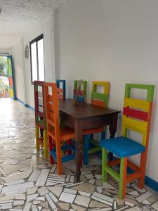 a room with a wooden table and colorful chairs at Ruta Jardín in Jardin