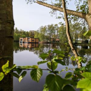 a house in the middle of a lake at Hausboot Lena in Papenburg