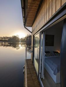 a bedroom on the side of a boat on the water at Hausboot Lena in Papenburg