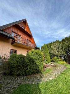 a house with a gambrel roof on the side of it at POD ROŻKAMI in Cisna