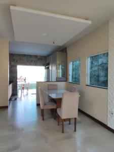 - une cuisine et une salle à manger avec une table et des chaises dans l'établissement Casa em Jauá, à Camaçari