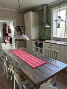 a kitchen with a wooden table with chairs around it at SwedishCountryLiving / Skippers cottage in Köpmannebro