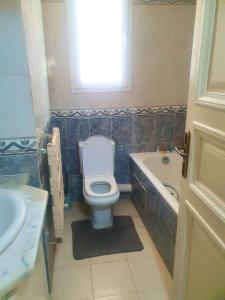 a bathroom with a toilet and a tub and a sink at Duplex Familial 2 Chambres 131m2 avec Jardin Privé - Service Aéroport - Internet Fibre Optique in Burj at Turkī