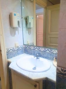 een badkamer met een wastafel en een spiegel bij Duplex Familial 2 Chambres 131m2 avec Jardin Privé - Service Aéroport - Internet Fibre Optique in Borj Turki
