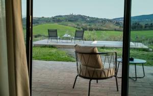 una camera con sedia, tavolo e patio di Mormoraia a San Gimignano