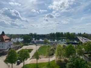 - une vue sur un parc avec un bâtiment et un lac dans l'établissement Ferienwohnung Rheinblick, à Kehl