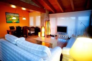 sala de estar con sofá blanco y TV en Hotel Villaro Del Bosc, en Freixinet